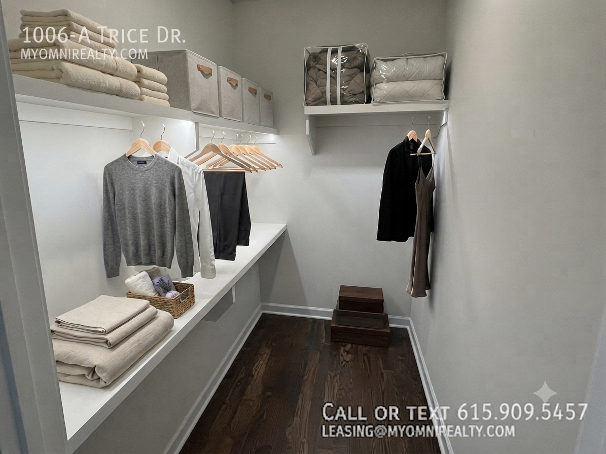 Bright walk-in closet with folded towels, storage boxes, shirts on hangers, and wooden boxes on a dark wood floor.